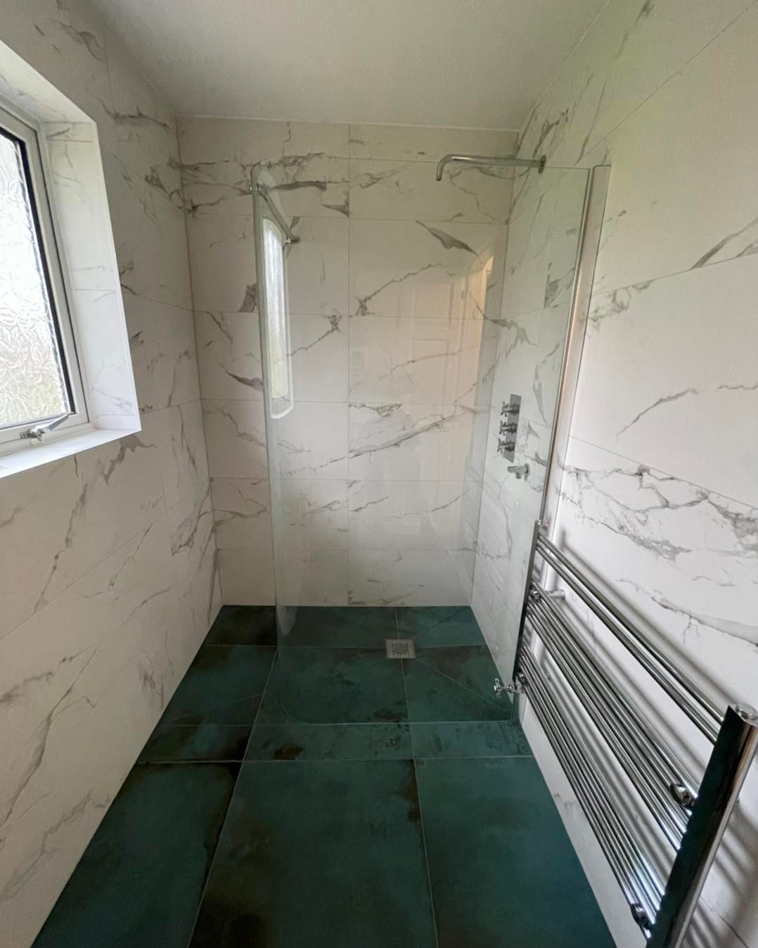 green and white marble tiled wet room