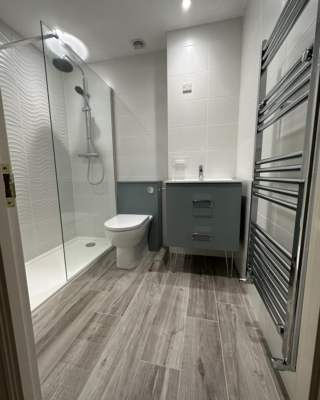 Modern textured white tiled shower in a bathroom