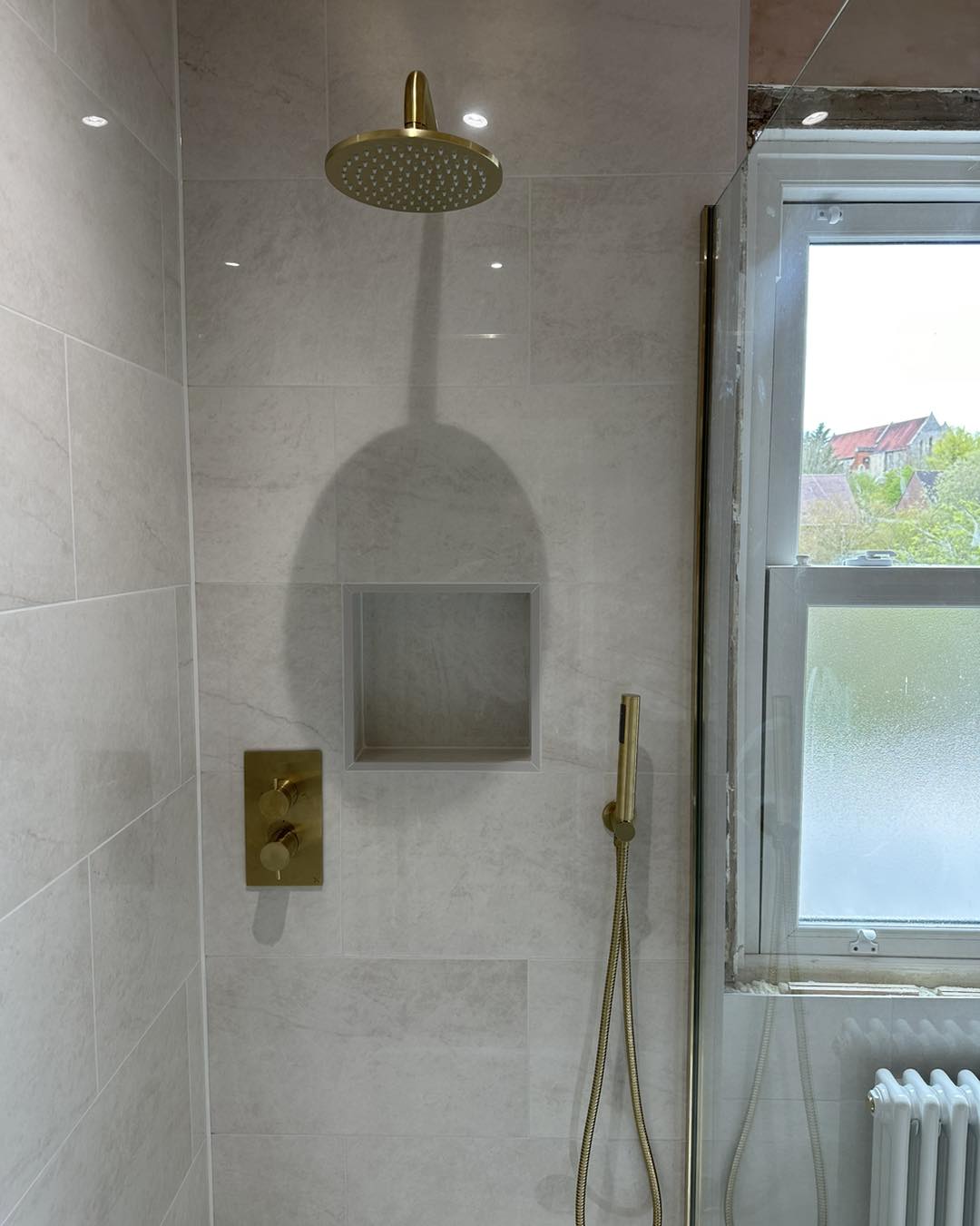 gold hardware in a waterfall shower with cut out