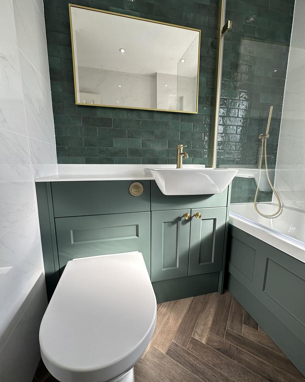 green and gold bathroom with wooden and herringbone floor