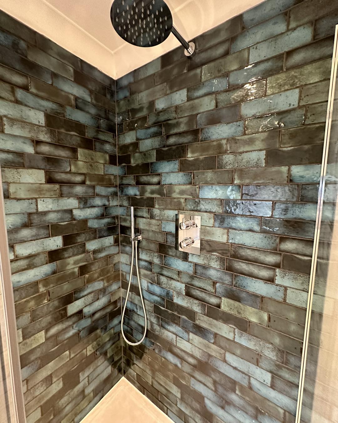 green and black iridescent tiled shower