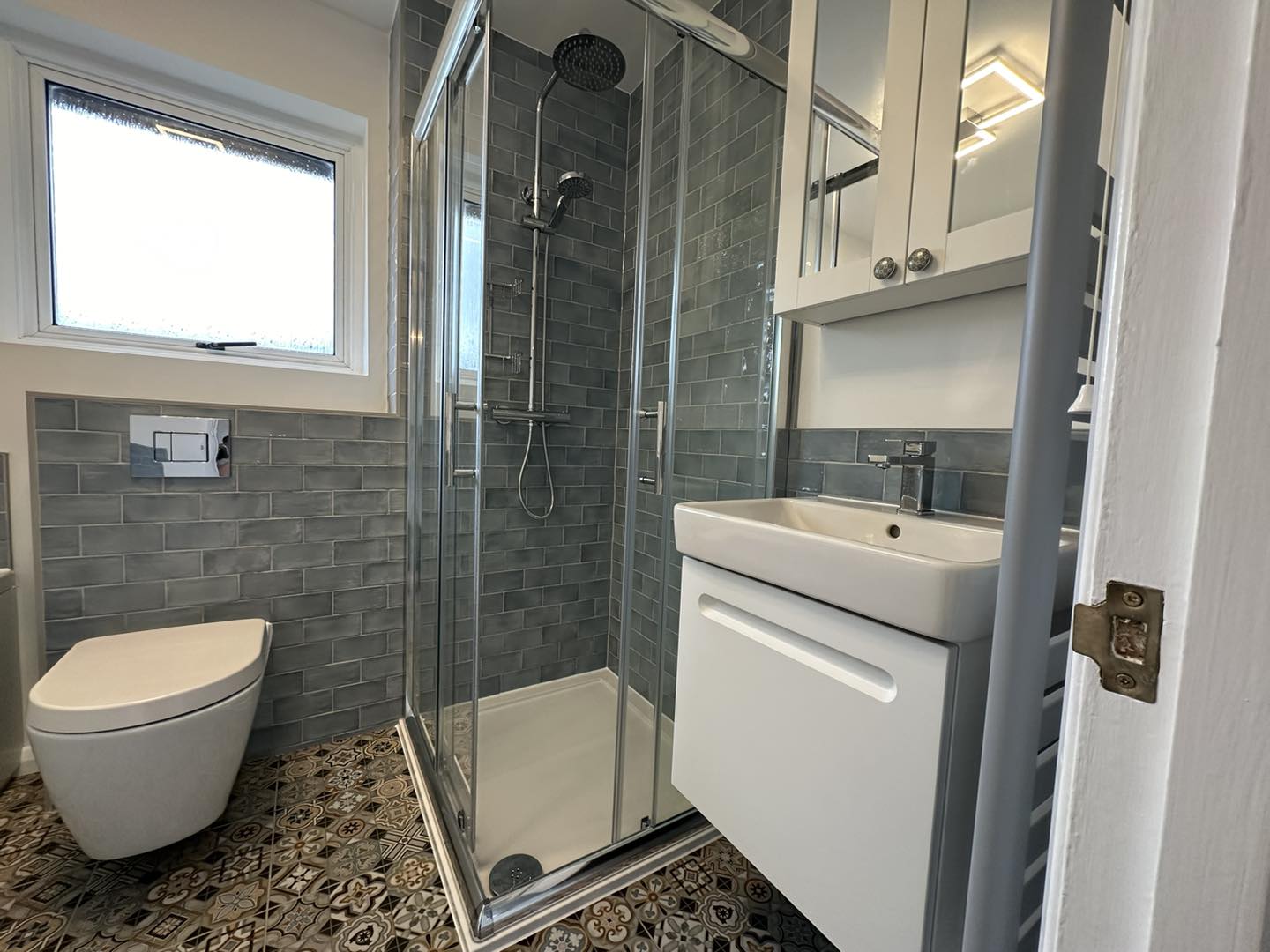 Grey tiled bathroom with patterned floor