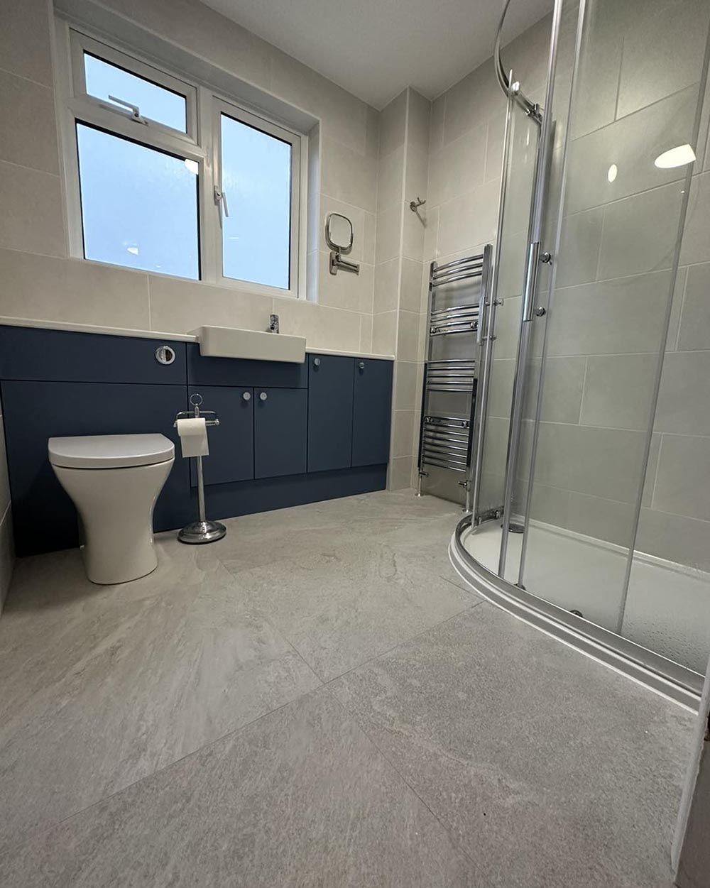 large grey floor tiles in a navy bathroom